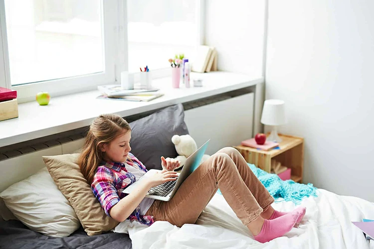 Teenager Girl on Bed with Laptop