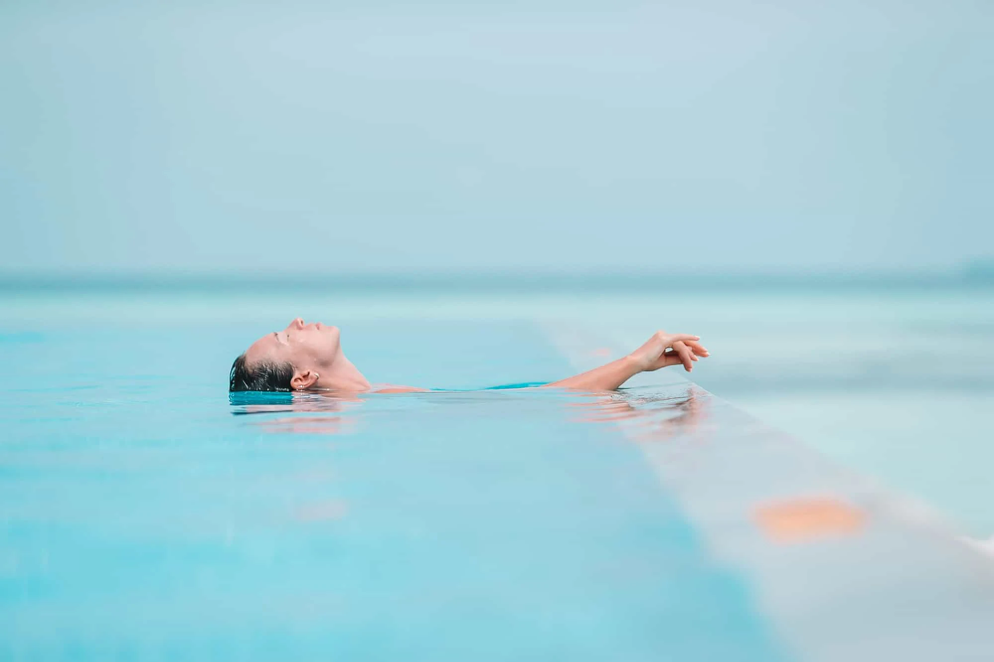 Young beautiful woman enjoying summer vacation in luxury pool